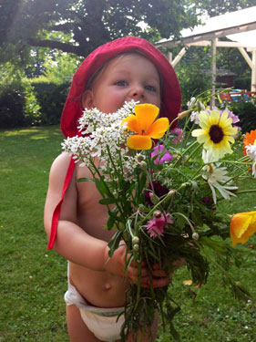 ein kleines Mädchen hat einen wunderschönen bunten Blumenstrauss in der Hand