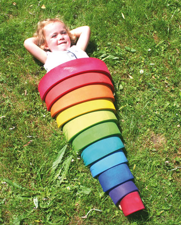 Kind versteckt sich unter einen Holz Regenbogen