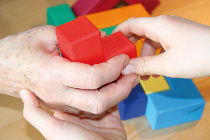 alte und junge Hände spielen zusammen