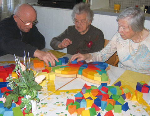 eine Seniorengruppe puzzelt den großen Schmetterling