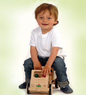 Kind sitz auf einem Nic Creamobil Holzauto mit Kippmulde